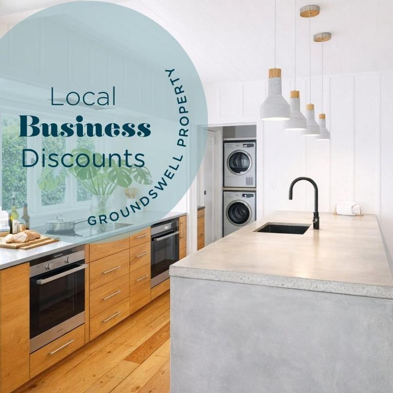 a white kitchen with a counter top and a sink at Raglan West Cottage, Surf Side Escape in Raglan