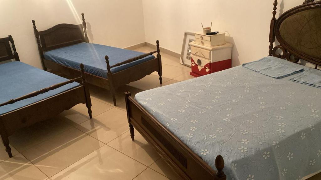 a room with three beds in a room at Casa Versátil in Ribeirão Preto