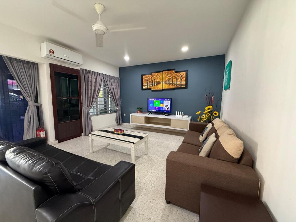 a living room with a couch and a tv at Ipoh Garden 4BR 10Pax in Ipoh