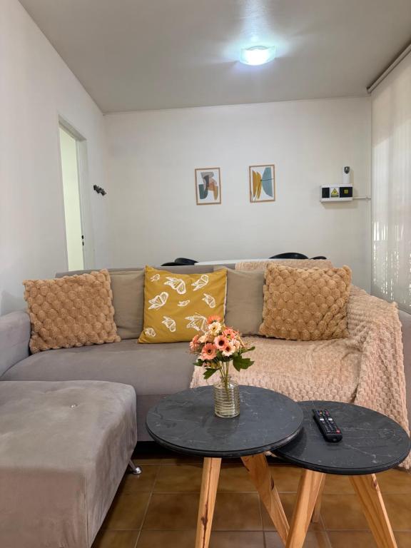a living room with a couch and a table with flowers at Casa amplia 3 dormitorios, 2 baños - Smart TV 50" - Entrada Autónoma - Pileta de Verano in Mendoza