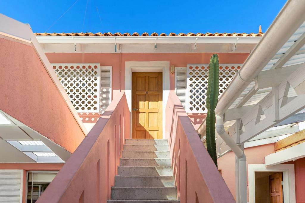 a staircase leading up to a house with a yellow door at Dolphins Backpackers in Sunshine Beach