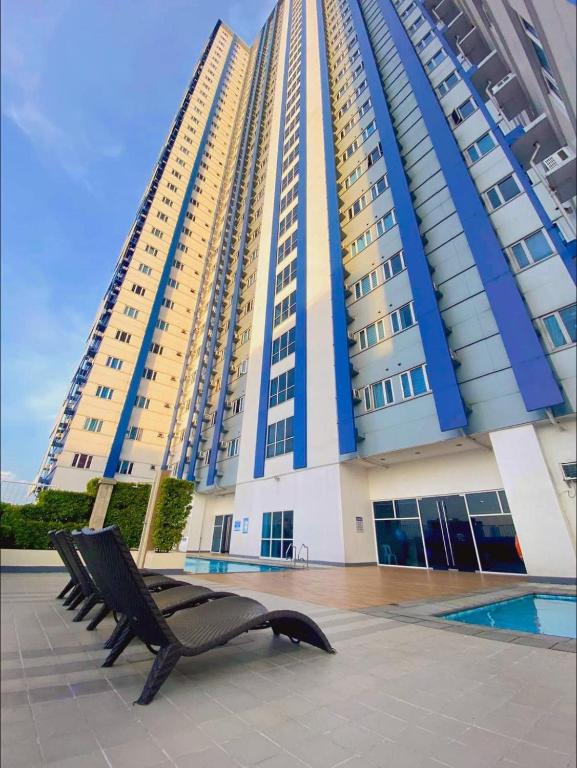 a black bench in front of a large building at Sweden's Tiny Home, Studio Unit Condo in Manila