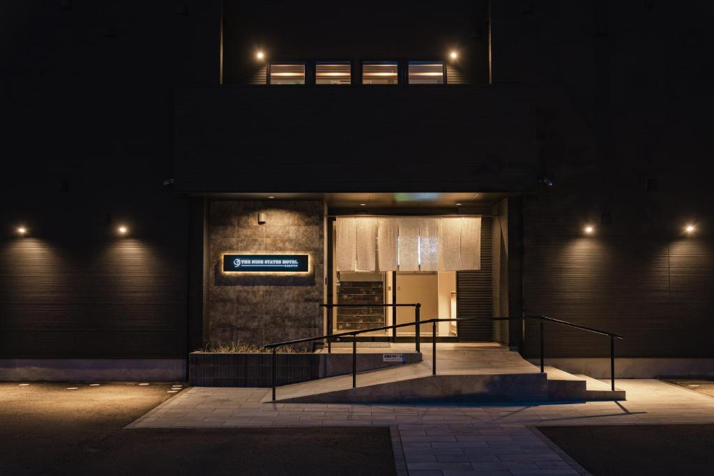 a building with a sign on it at night at The Nine States Hotel KARATSU in Karatsu