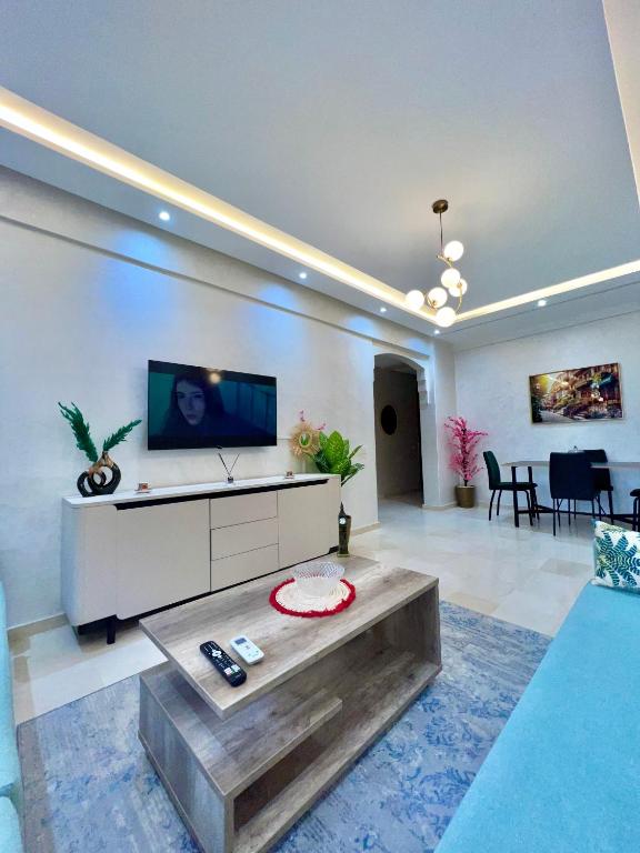 a large living room with a tv and a table at Oasis Gueliz Center Marrakech in Marrakesh