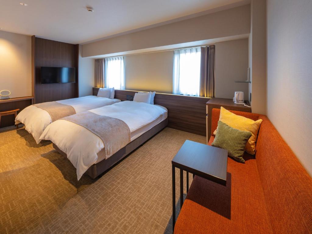 a hotel room with a large bed and a couch at New Osaka Hotel in Osaka