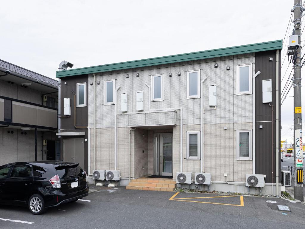 a black car parked in front of a building at Tabist Ishinomaki in Ishinomaki
