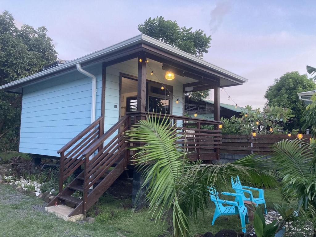 a tiny house with a porch and a blue bench at Rainbow beach Bungalow in Matura