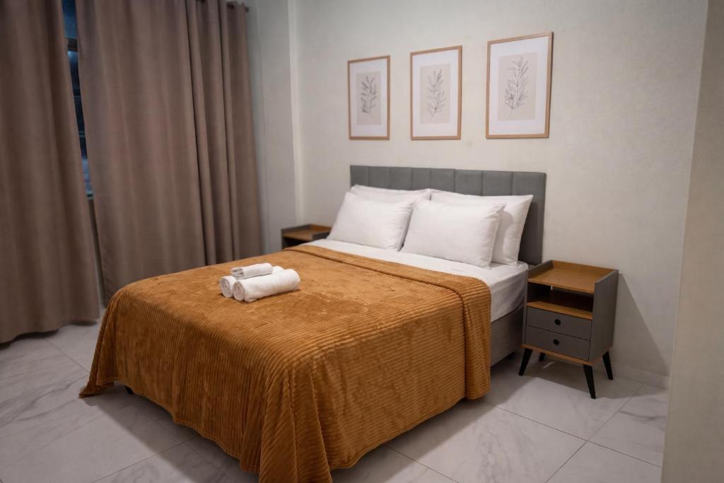 a bedroom with a bed with a orange blanket at Apto no Centro de Miguel Pereira in Miguel Pereira