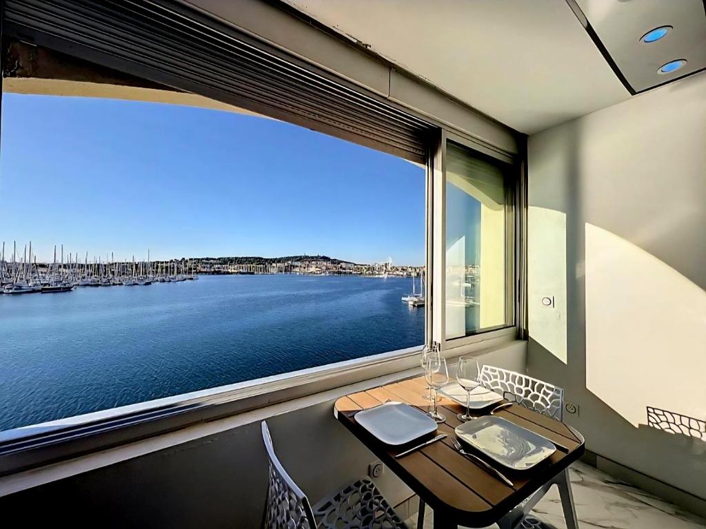 a table and chairs in a room with a large window at 240 Magnifique Appart Deluxe vue mer in Cap d'Agde