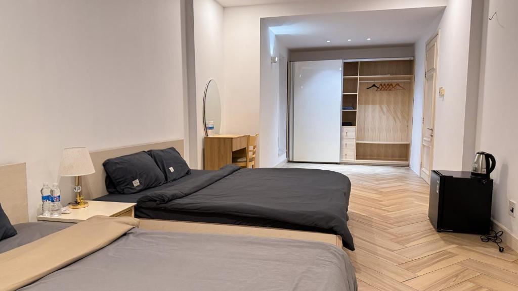 a bedroom with two beds and a television in it at The LH Homestay in Phú Quốc