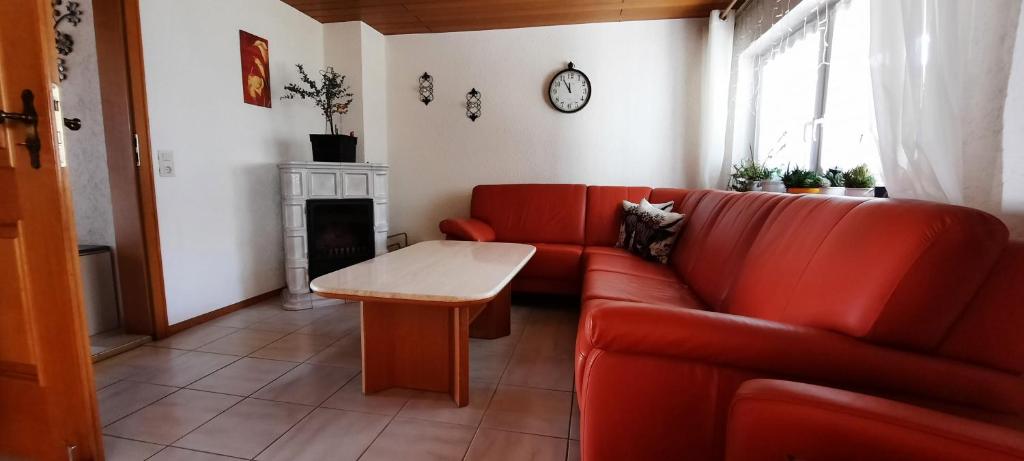a living room with a red couch and a table at Monteurwohnung in Patersdorf