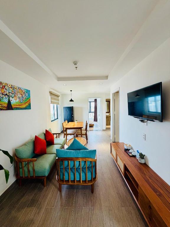 a living room with a couch and a tv at The Shine Hotel & Apartment in Danang