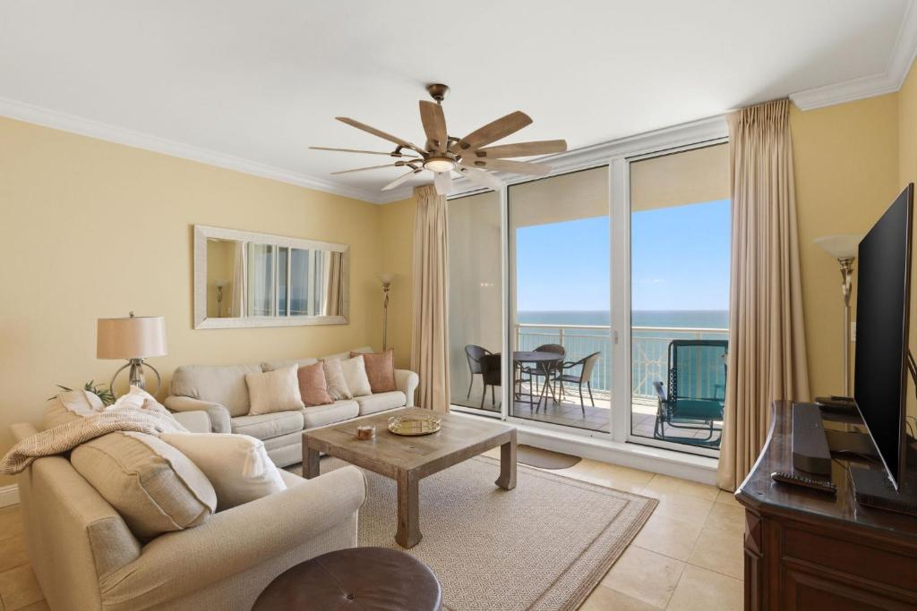 a living room with a couch and a large window at PRIVATE BEACH FRONT LUXURY CONDO, AMAZING VIEWS, INDiGO E, 5-STAR, 2 BALCONIES , PREFERRED PARTNER PRG in Pensacola