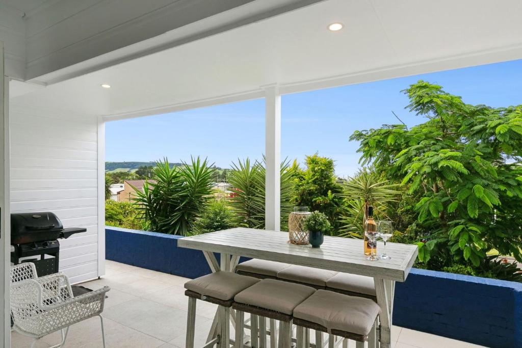 a patio with a table and chairs and a grill at Blue View Gerringong in Gerringong