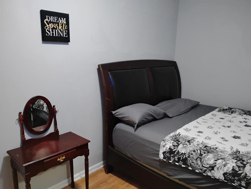 a bedroom with a bed and a table and a mirror at Grove 4- Queen bed with Private bathroom in Irvington