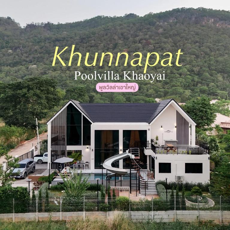 a house with a playground in front of a mountain at Khunnapat Pool Villa Khaoyai in Mu Si