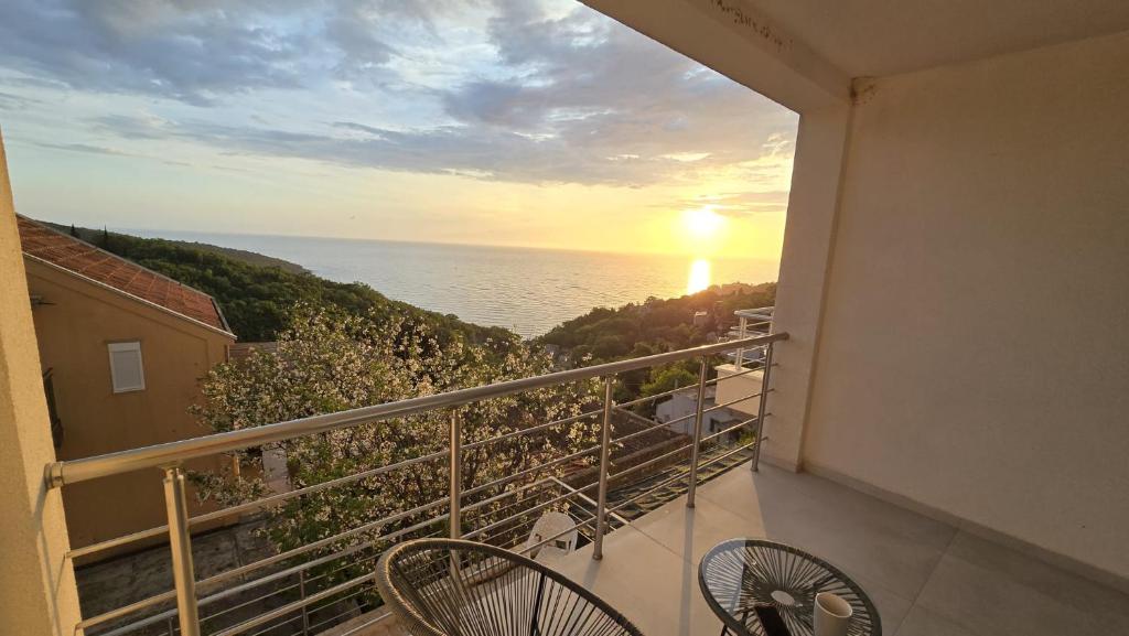 a balcony with a view of the ocean at sunset at Apartman Triton in Ulcinj