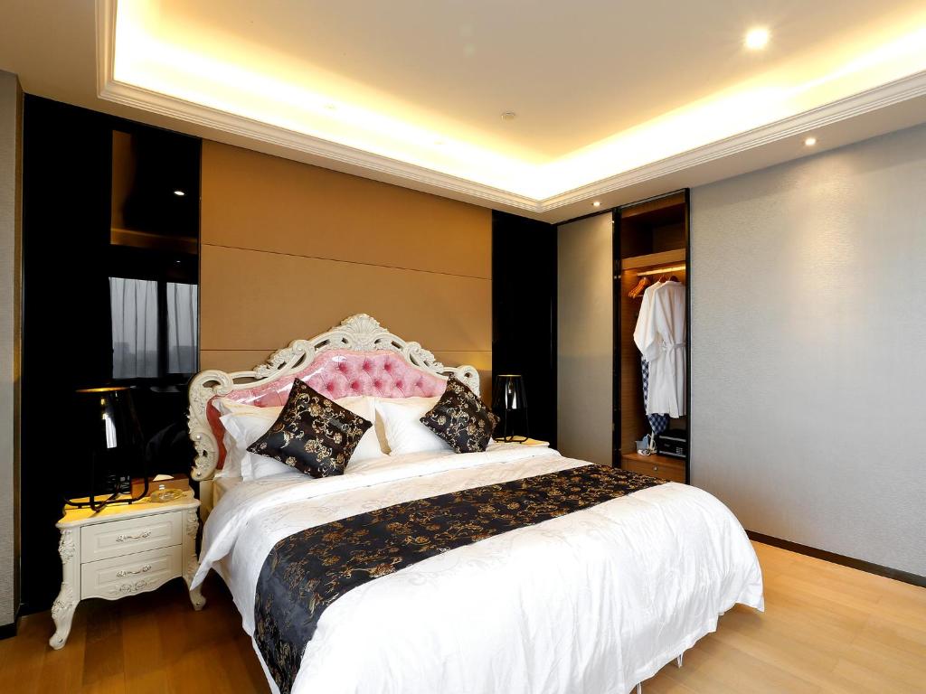 a bedroom with a large white bed with pillows at Pengman Beijing Rd. A-mall Apartment in Guangzhou