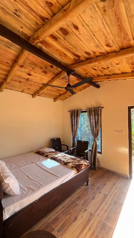 a bedroom with a large bed and wooden ceilings at Luvyash Campsite Stays in Bhīm Tāl