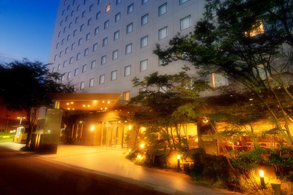 a building with lights in front of it at night at Kanazawa Manten Hotel Ekimae in Kanazawa