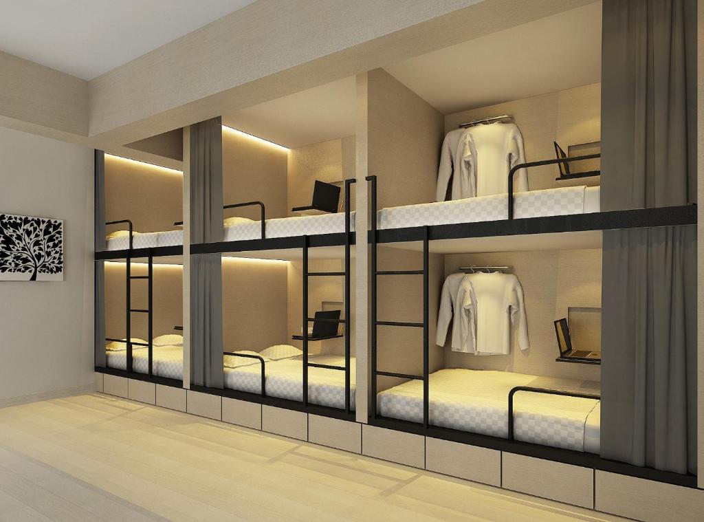 a room with four bunk beds with mirrors at 7 Wonders Boutique Capsule in Singapore