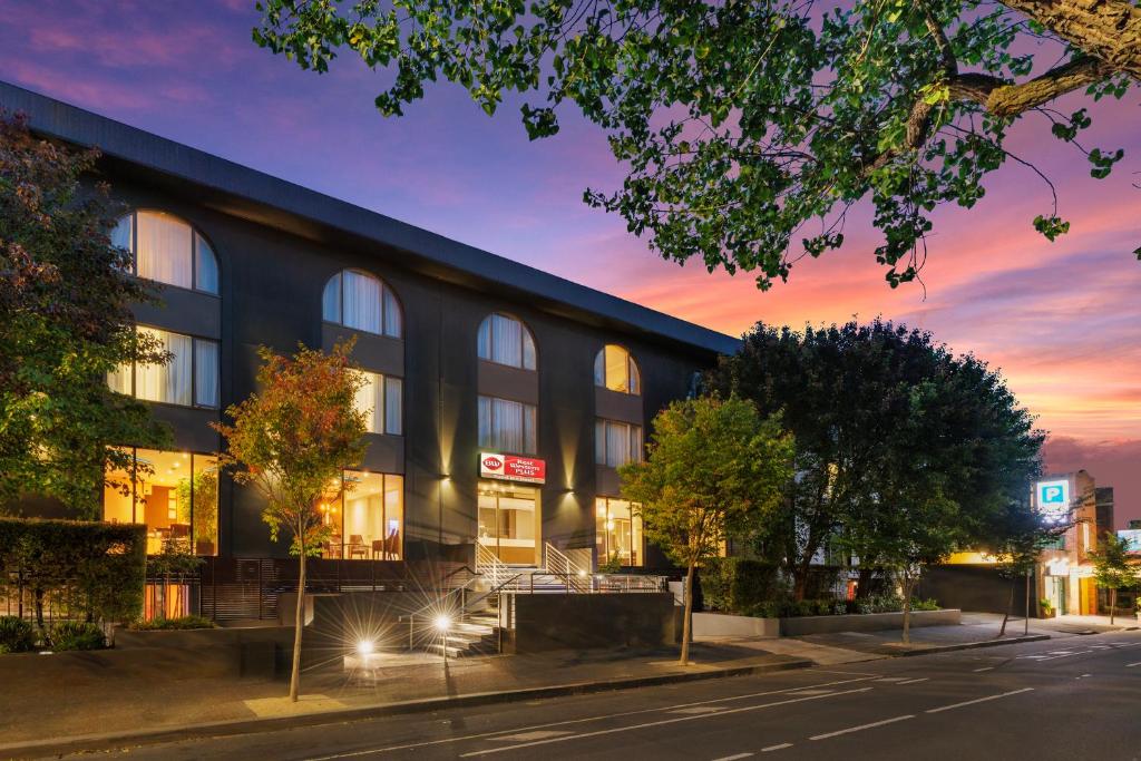 a building on a street with a sunset at BEST WESTERN PLUS Travel Inn in Melbourne
