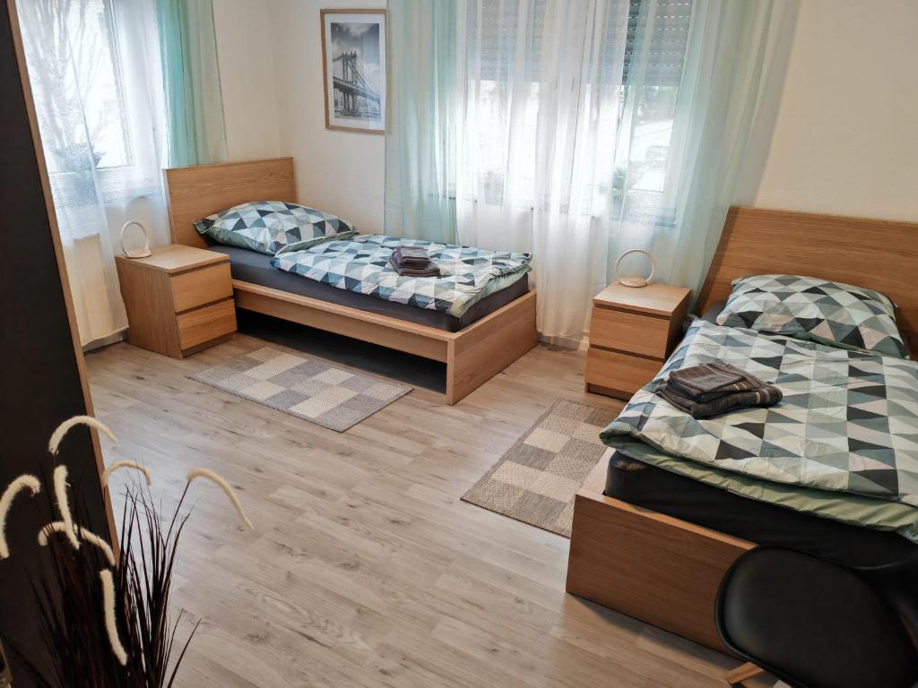 two beds in a room with wooden floors at NEU Monteurhaus und Ferienhaus 5 Betten Parkplatz 24h Checkin in Alsdorf