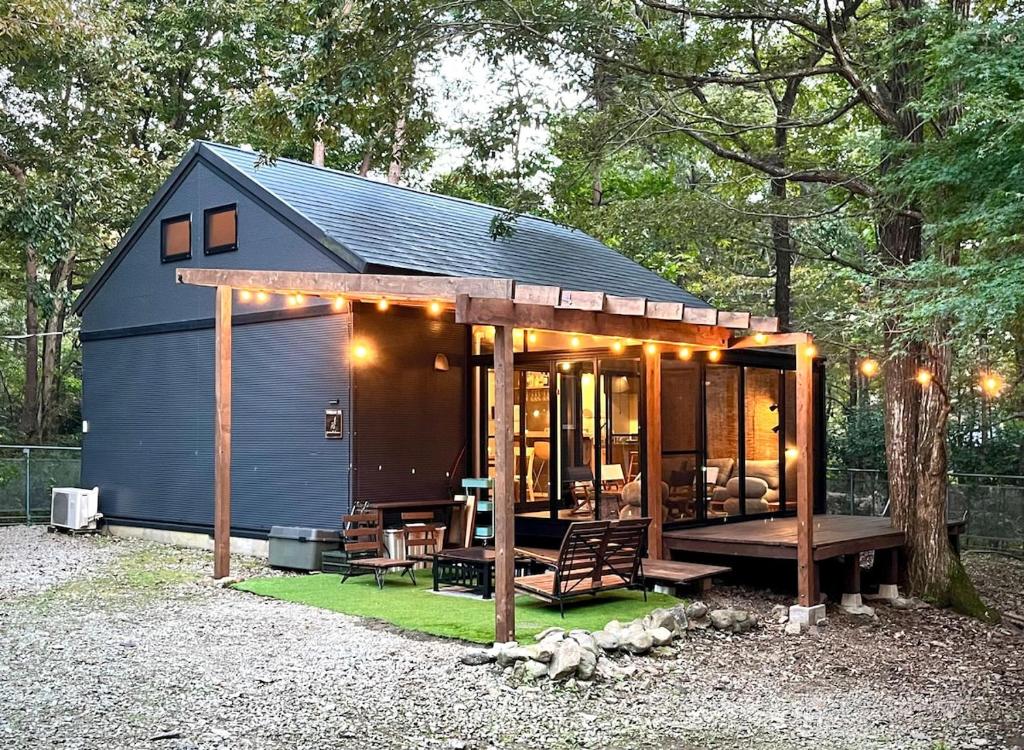 a tiny house with a porch and a patio at Forest 99 in Nasushiobara