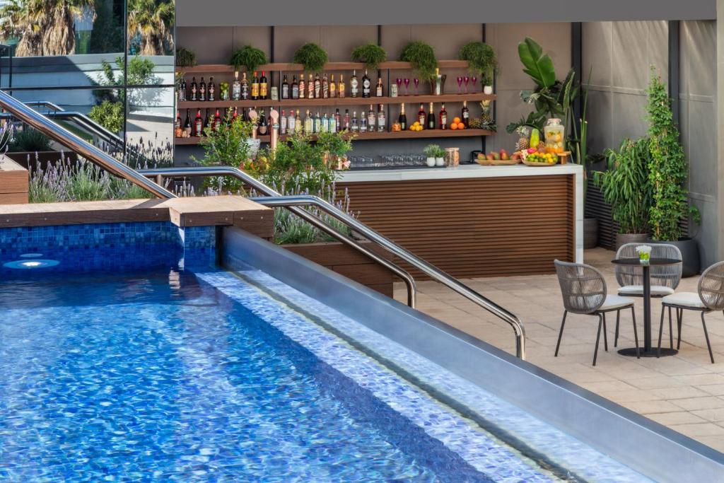a swimming pool with a bar next to a restaurant at Meliá Valencia in Valencia