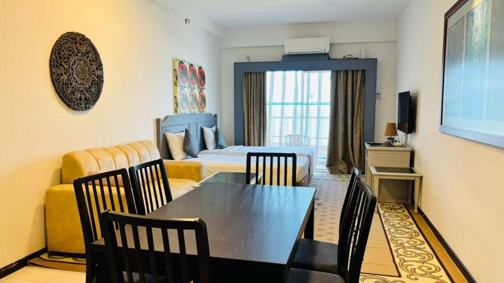 a room with a dining table and a bedroom at Rainbow Paradise Seaview by Achlys Collection in Tanjung Bungah