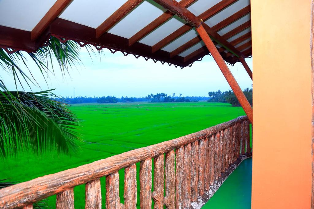 einen Balkon mit Blick auf ein grünes Feld in der Unterkunft V Cabanas in Tissamaharama
