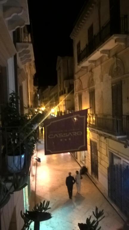 dwoje ludzi spacerujących nocą ulicą w obiekcie Dimora di Charme Cassaro 168 w mieście Marsala