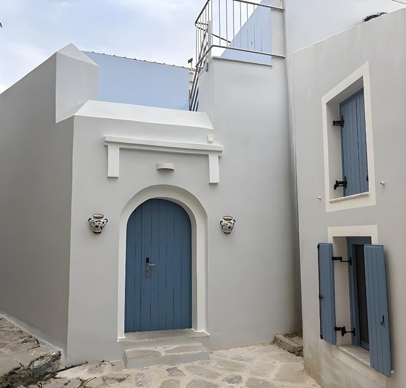 a blue door on the side of a white building at Aleminas Rooms 2 in Symi