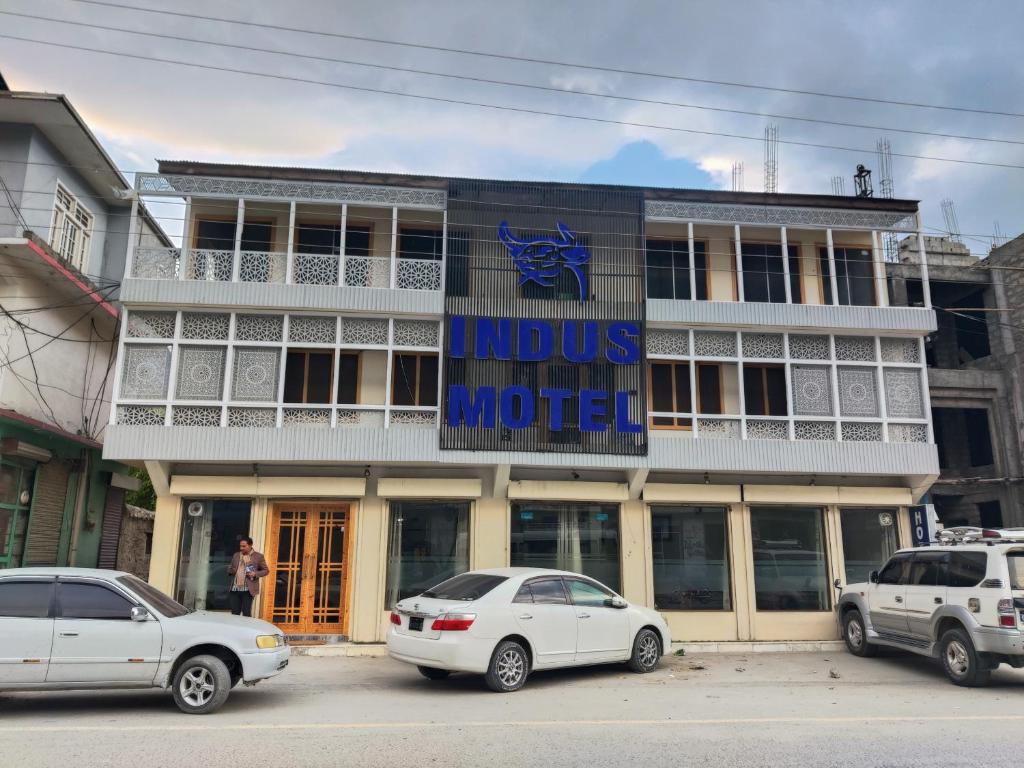 a building with cars parked in front of it at Indus Motel in Skardu