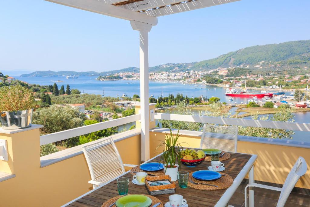 una mesa en el balcón con vistas al agua en Saint George Villas & Apartments, en Skiathos