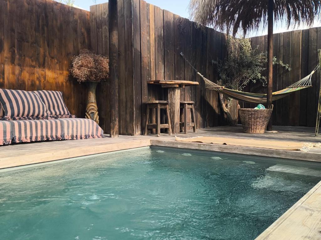 a swimming pool in front of a wooden fence at הבית החום בערבה in Sappir
