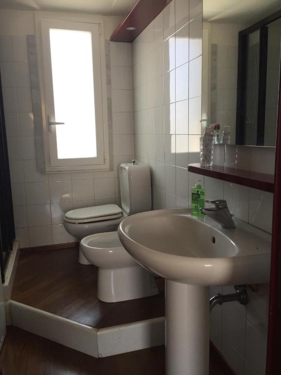 łazienka z umywalką, toaletą i oknem w obiekcie La casa di Teseo w mieście Cannizzaro