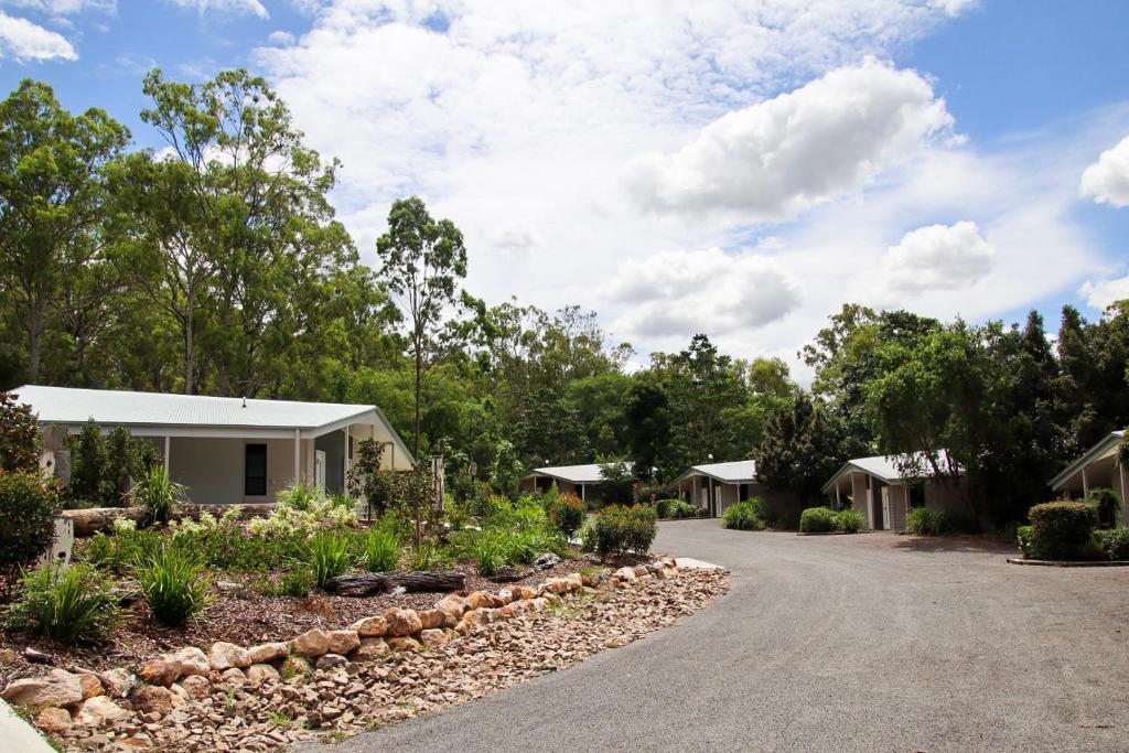a house with a garden in front of a driveway at Boonah Valley Motel in Boonah