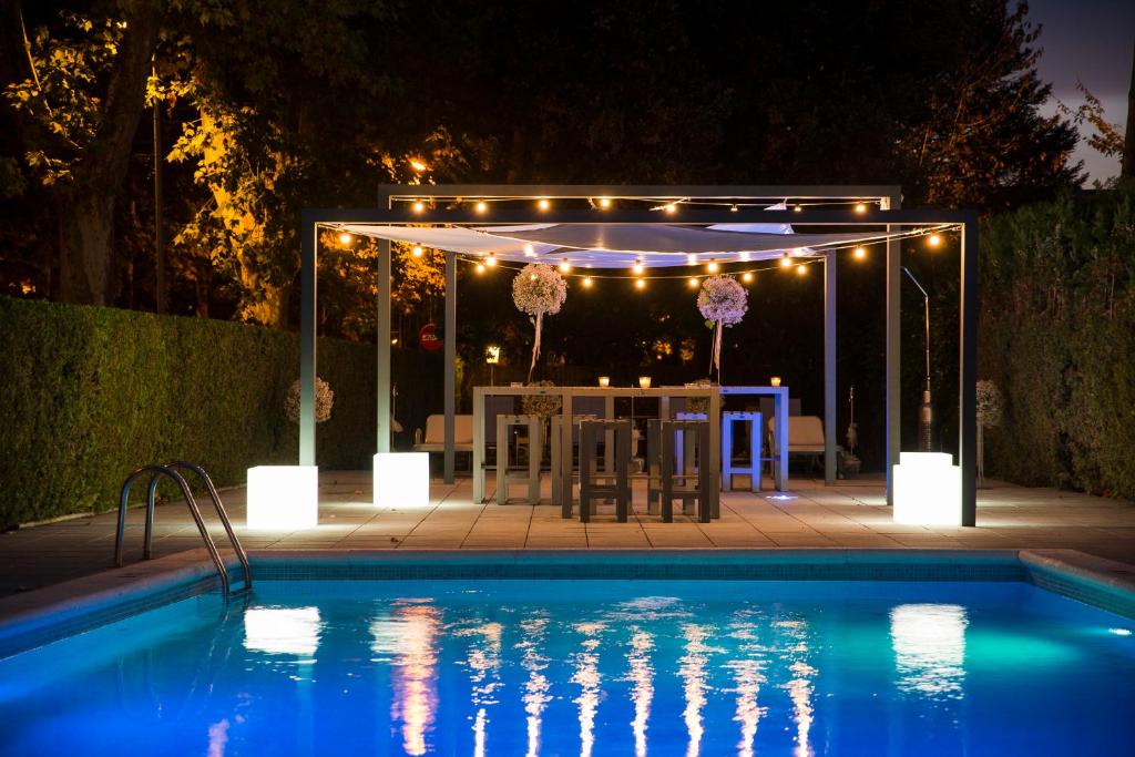a patio with a table and a pool at night at Apartament L'Ast in Banyoles