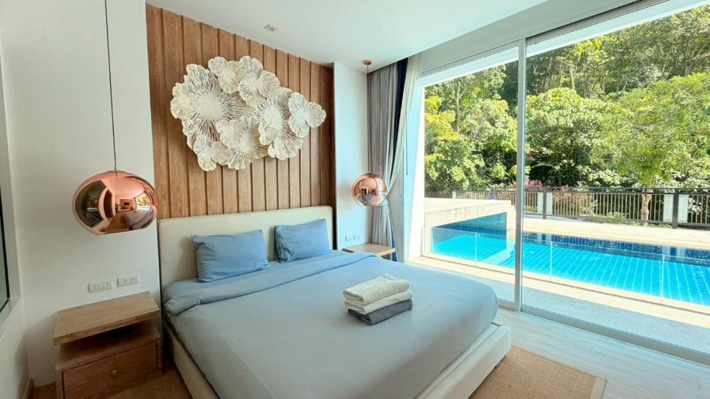 a bedroom with a bed and a swimming pool at Grand Kamala Falls in Kamala Beach