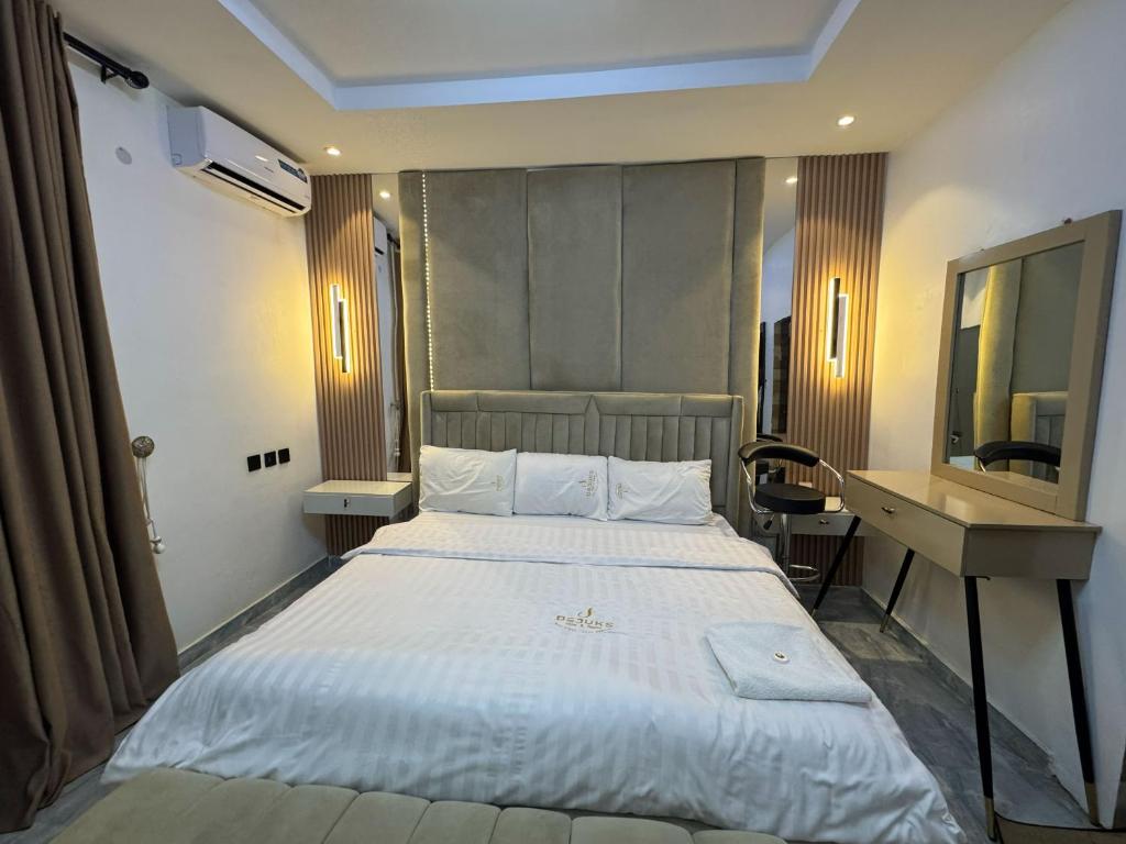 a bedroom with a large bed and a sink at Dejuks Hotel & Resort Executive Room in Mama