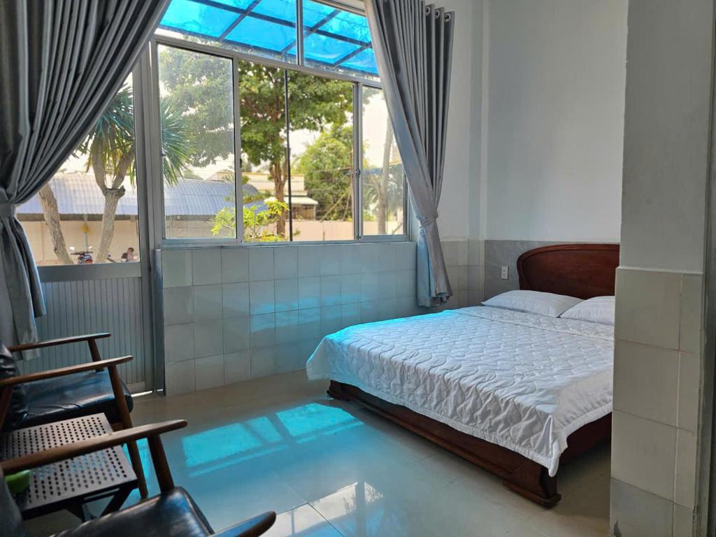 a bedroom with a bed and a large window at khách sạn Mya in Ấp An Hòa (2)