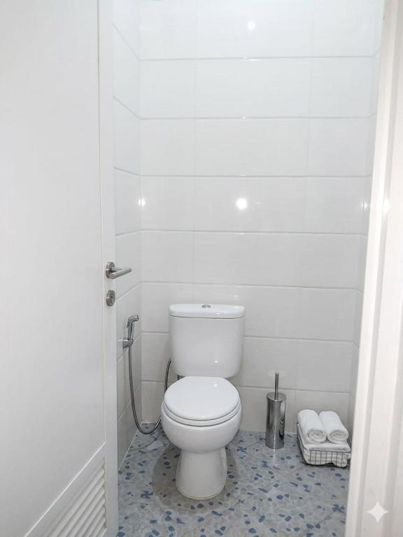 ein Badezimmer mit einer weißen Toilette in einem Zimmer in der Unterkunft Mesirom B&B in Dili
