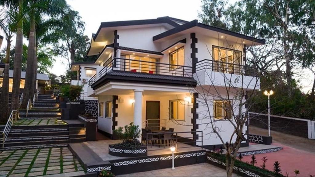 a white house with a staircase in front of it at Esperanza Villas by SVAR Stays in Panchgani