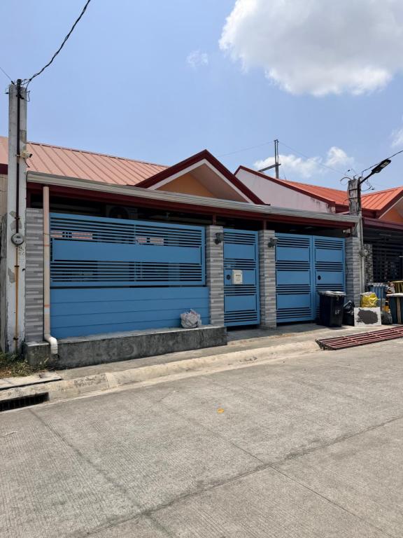 a house with blue garage doors on a street at serene genar in General Trias