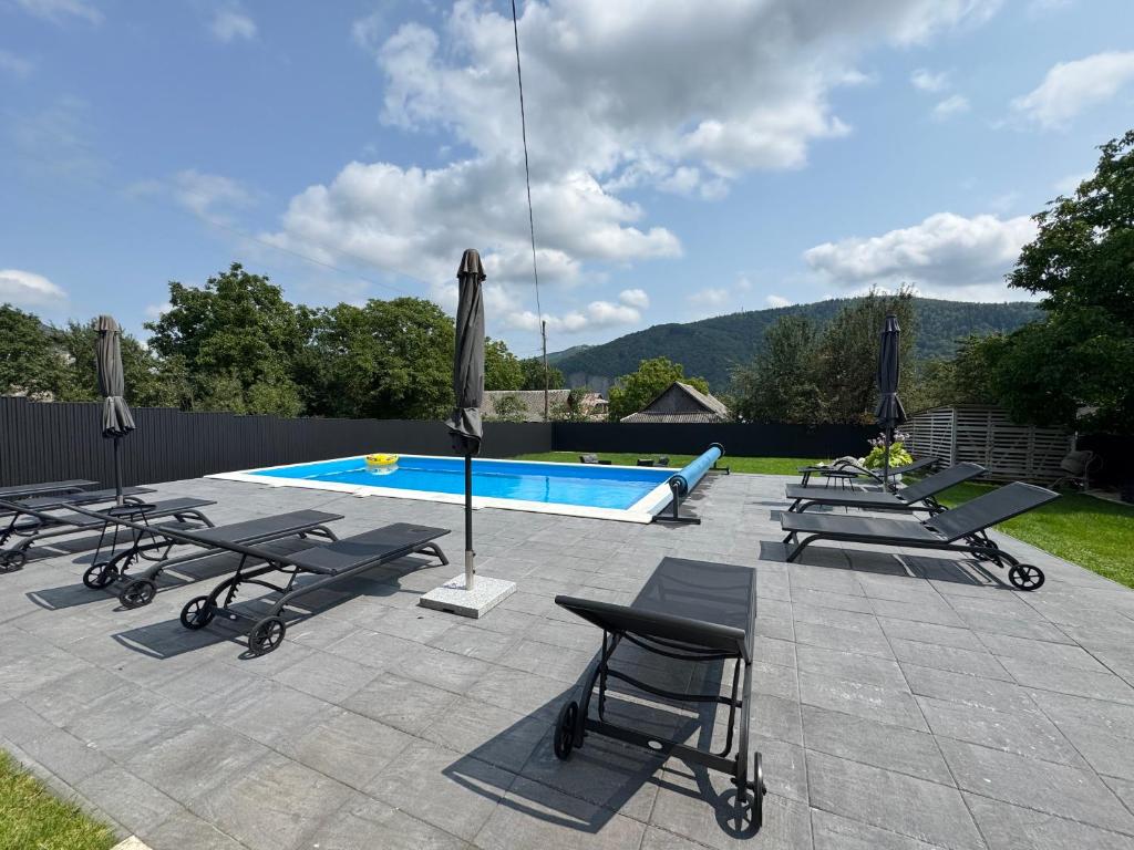 a group of lounge chairs and a swimming pool at Garage in Yaremche