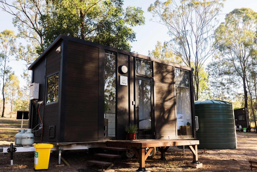 a black tiny house sitting on a table at Kenny and Clancy's Camp by Tiny Away in Grandchester
