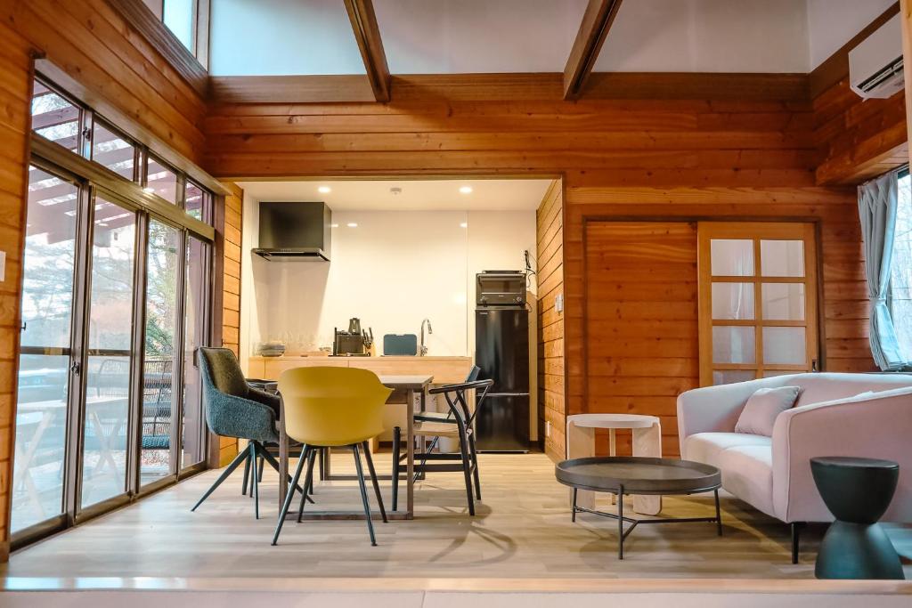 a kitchen and living room with a table and chairs at rinne 北軽井沢 Forest2 in Tsumagoi