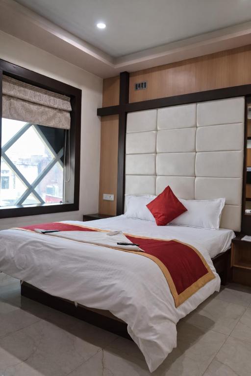 a bedroom with a large bed with a large window at Hotel Benaras Gharana Inn in Varanasi