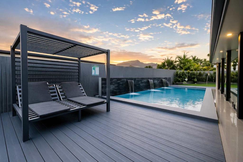 a deck with a bench next to a swimming pool at Magic on MacArthur - Modern 4BR Home in Annandale in Rosslea